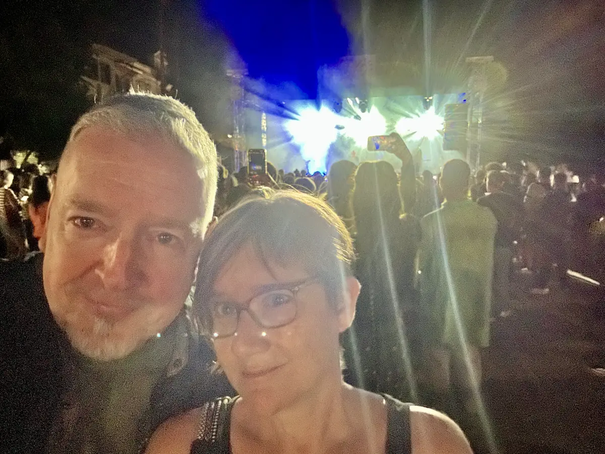 Maya Middlemiss and Richard Middlemiss at an open-air rock festival in Bansko at night, stage lights behind the crowd